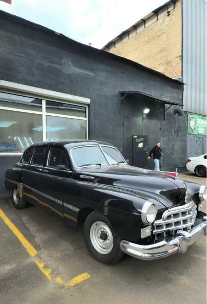 Vintage black car parked outside building